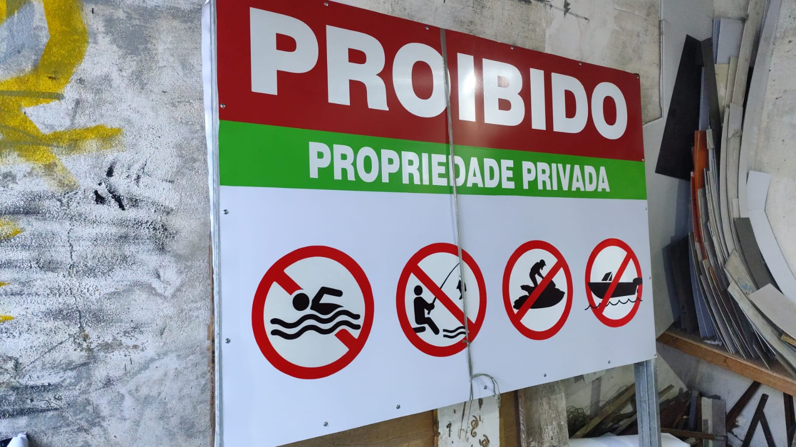 Placa 'Proibido - Propriedade Privada' com ícones de restrição de acesso