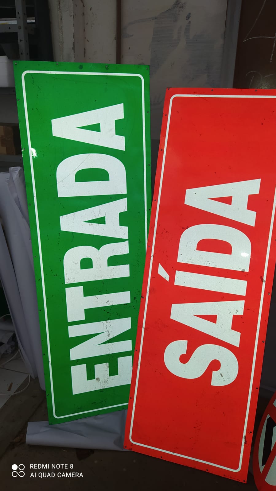 Placas de sinalização 'Entrada' e 'Saída' em verde e vermelho